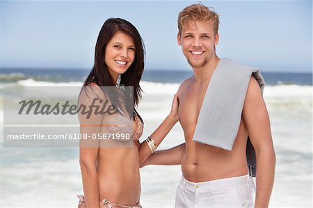 Portrait of a cheerful young couple standing on a beach