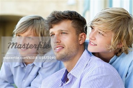 Smiling man and children looking away together