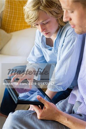 Man and a little boy looking at digital tablet