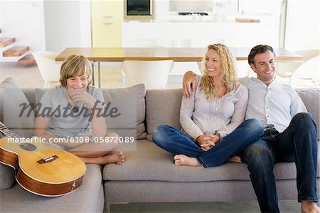 Family sitting on a couch and smiling