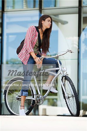 Jeune femme assise sur un vélo