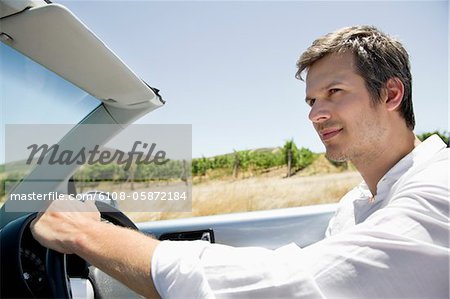 Mitte erwachsenen Mann fahren ein aufklappbares Auto