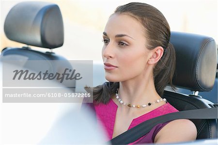 Young woman driving a convertible car