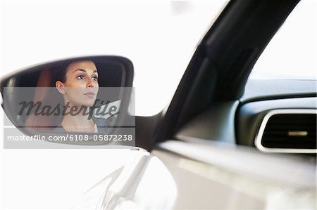 Reflexion einer jungen Frau auf der Seite Autoglaserei während der Einnahme einer Probefahrt