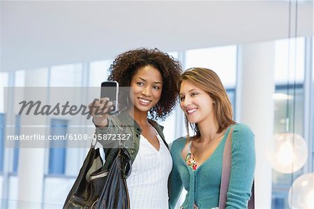 Two women taking photos of themselves