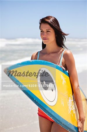 Woman holding a surfboard on the beach