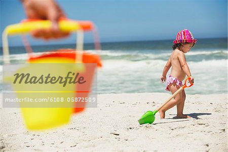 Profil de côté d'une fille se promener avec pelle à sable sur la plage
