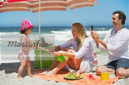 Femme tirant sur la pelle de la mère sur la plage