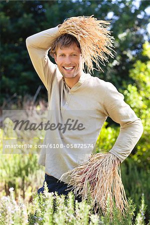 Portrait of a man standing in a field as scarecrow