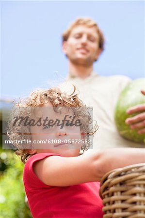 Low angle view of father and son holding fruits