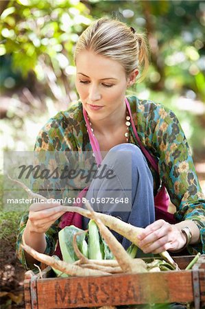 Femme assise près d'une caisse de radis