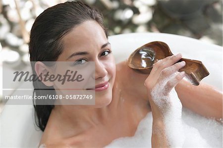 Portrait of a beautiful young woman taking bubble bath