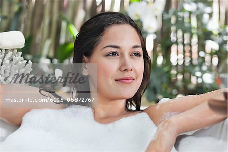 Beautiful young woman taking bubble bath
