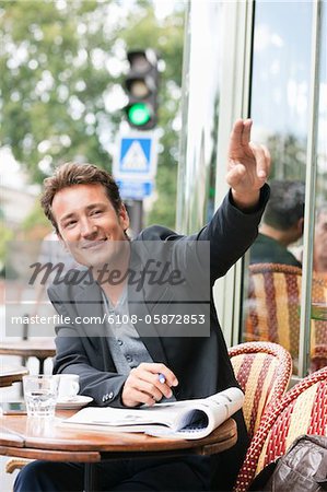Man signaling for waiter in a restaurant, Paris, Ile-de-France, France