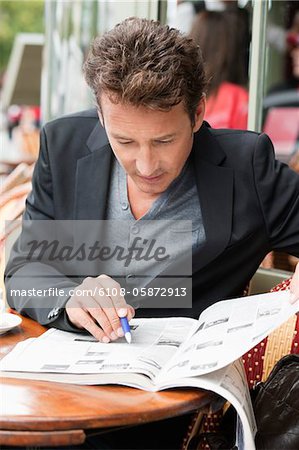 Man reading a magazine in a restaurant, Paris, Ile-de-France, France