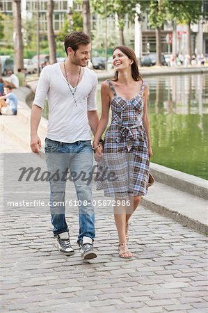 Couple walking near a canal and smiling, Paris, Ile-de-France, France