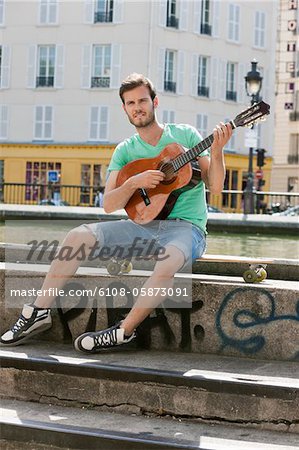 Man playing a guitar, Canal St Martin, Paris, Ile-de-France, France