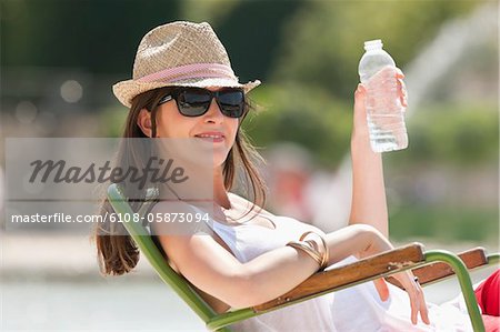 Woman sitting in a chair and drinking water, Bassin octogonal, Jardin des Tuileries, Paris, Ile-de-France, France