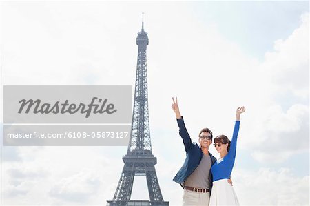 Couple waving hands with the Eiffel Tower in the background, Paris, Ile-de-France, France