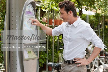 Man looking a map in a ticket machine, Paris, Ile-de-France, France Man looking a map in a ticket machine, Paris, Ile-de-France, France