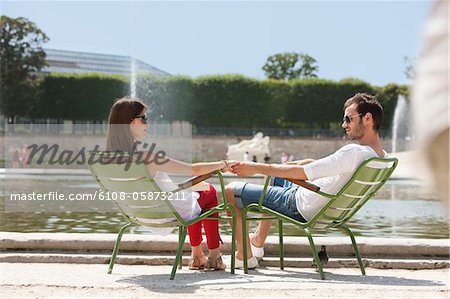 Couple sitting in chairs near a pond, Bassin octogonal, Jardin des Tuileries, Paris, Ile-de-France, France
