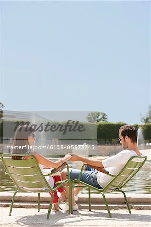 Couple assis dans des chaises près un étang, Bassin octogonal, Jardin des Tuileries, Paris, Ile-de-France, France