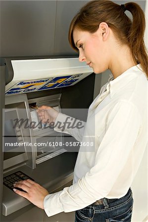 Side profile of a businesswoman using an ATM