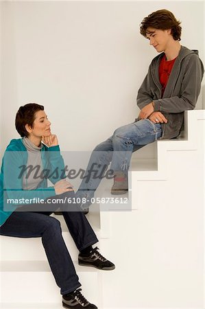 Mid femme adulte et son fils assis sur un escalier