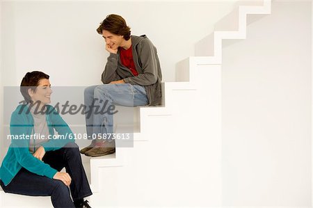 Frau mittleren Alters und ihr Sohn sitzt auf einer Treppe