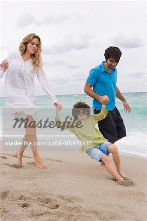 Couple playing with their son on the beach