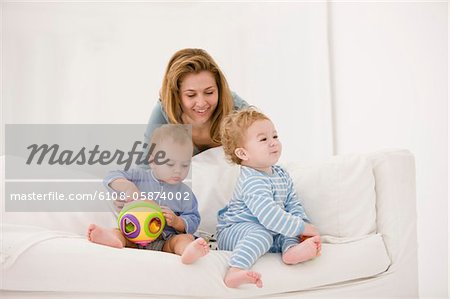 Woman playing with her son and daughter on a couch