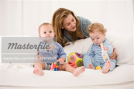 Woman playing with her son and daughter on a couch