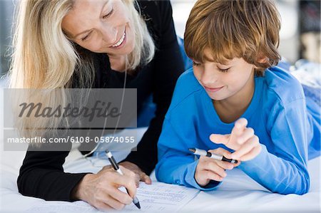 Woman helping her son in his homework