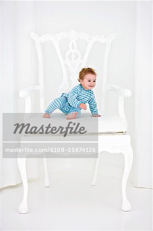 Baby boy sitting in an armchair