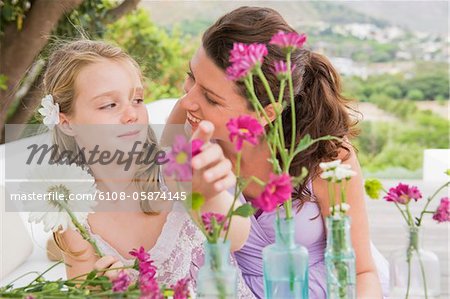 Woman with her daughter arranging flowers in a vase