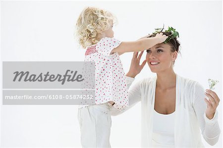 Girl putting a wreath on her mother's head