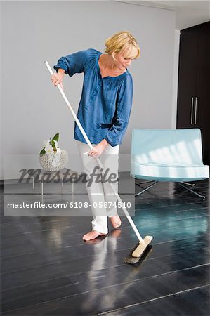 Femme en nettoyant le plancher avec une vadrouille