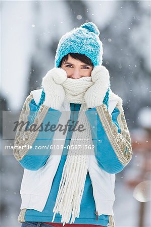 Jeune femme en souriant à la caméra des vêtements d'hiver