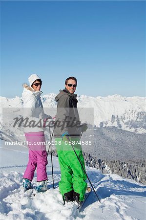 Jeune couple de skieurs, regardant en arrière