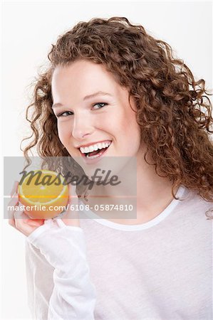 Portrait d'une femme tenant une moitié d'orange et de rire