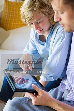 Mann und ein kleiner Junge betrachtet man digitale tablet