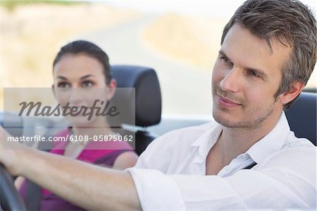 Couple driving a convertible car