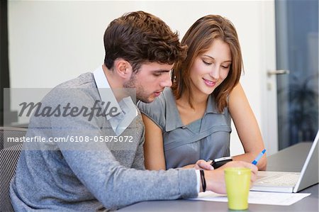 Universität Studenten Text messaging mit Laptop im Klassenzimmer