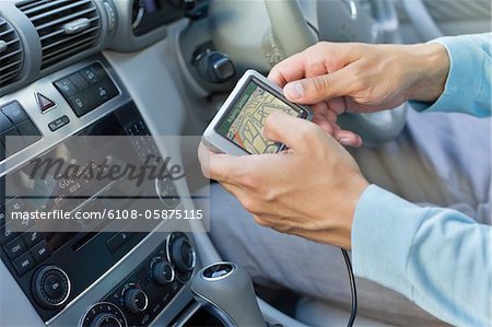 Nahaufnahme der menschlichen Hand mit GPS-Navigationssystem im Auto