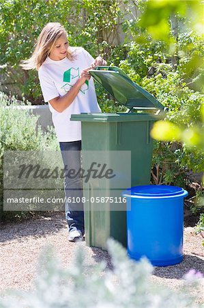 Femme regardant dans le bac de recyclage