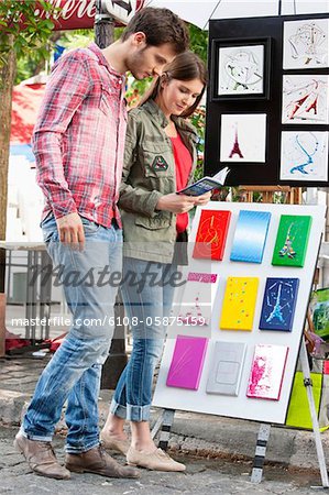 Couple looking at Ansichtskarten von Eiffelturm am Marktplatz, Paris, France, Frankreich