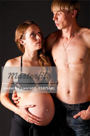 pregnant woman and her man on black background