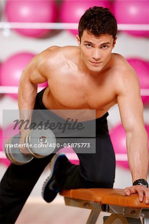 Handsome man at the gym doing exercises