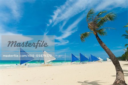 traditional paraw sailing boats on white beach on boracay island, philippines