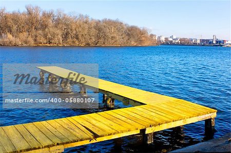 Old wooden pier at the city water reservoir in a fine late autumn day